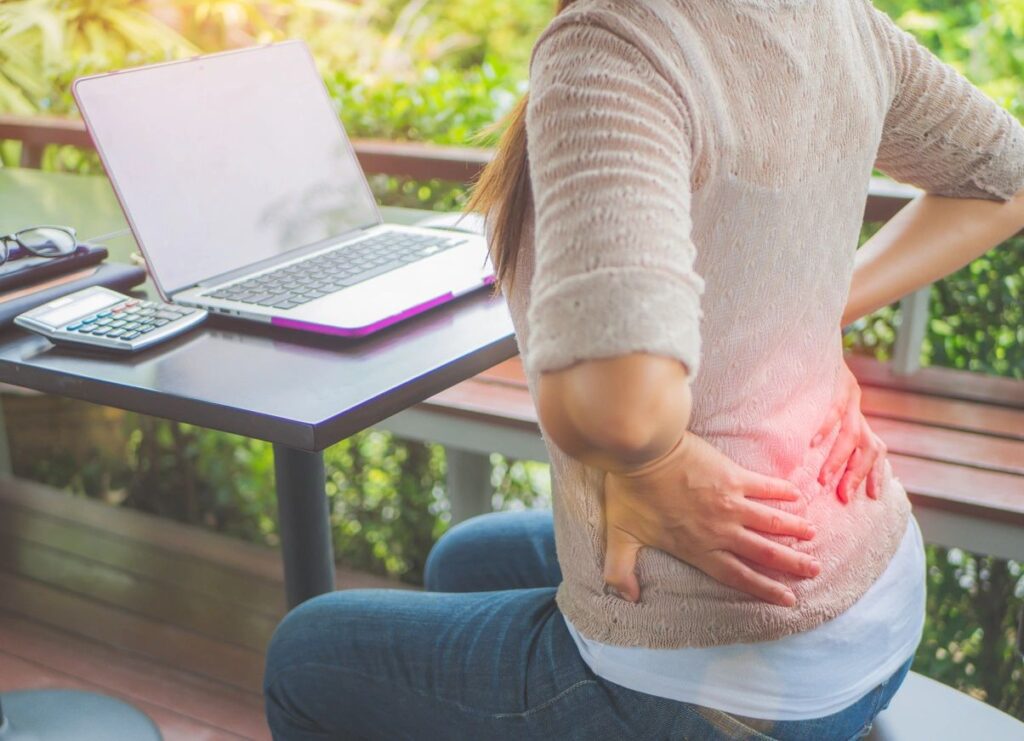 A person sitting on the ground with their hands in their pockets.