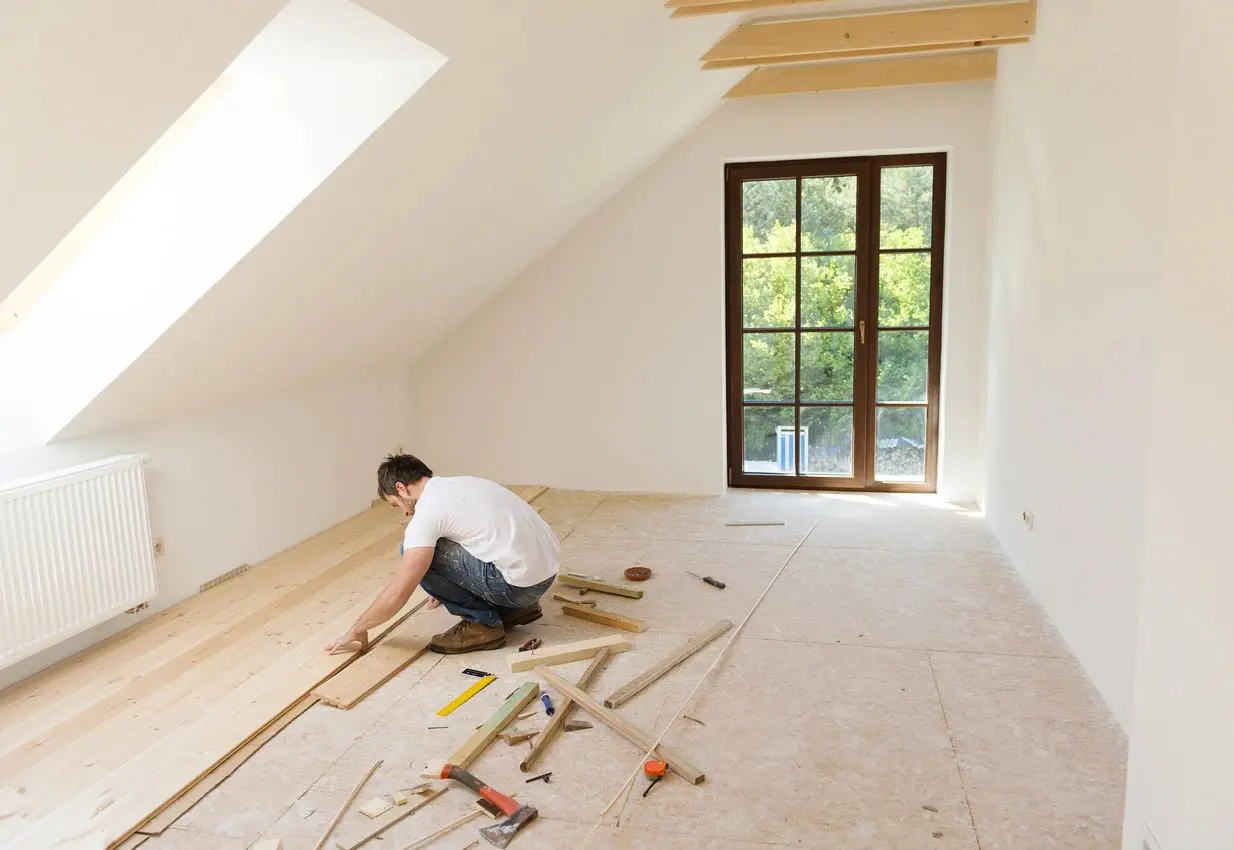 A man is laying down in the floor of his home.